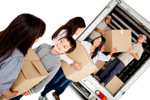 Commercial removals vehicle loading office items in a narrow street
