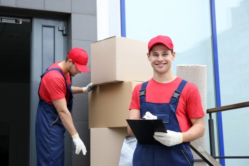 Mover carrying a sofa with protective gear during a safe house move