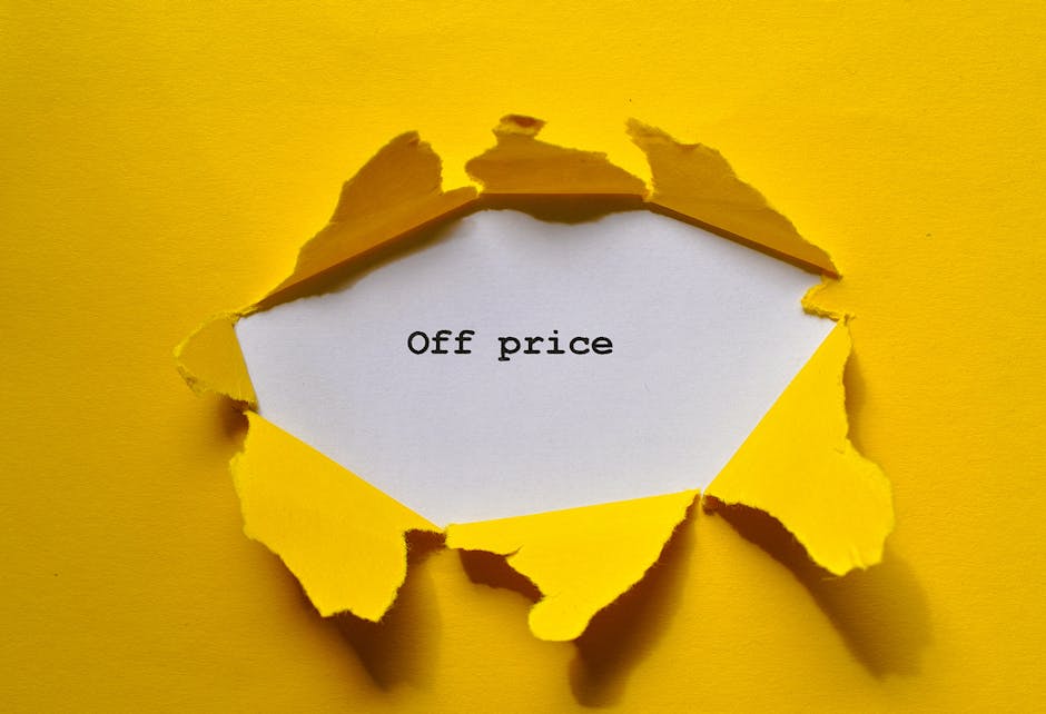 A close-up of a yellow paper surface with a large, irregular tear revealing a white insert beneath. The torn edges are jagged and curled outward, with some pieces still partially attached to the background. On the white insert, the words 'Off price' are printed in black typewriter-style font. The image captures the process of uncovering or revealing a hidden message, which subtly relates to the concepts of moving and unpacking in a home relocation context. The yellow background and torn paper emphasize the idea of uncovering or revealing items during furniture transport or packing for house removals, consistent with the services offered by Man with Van St Margarets in their moving and packing processes.