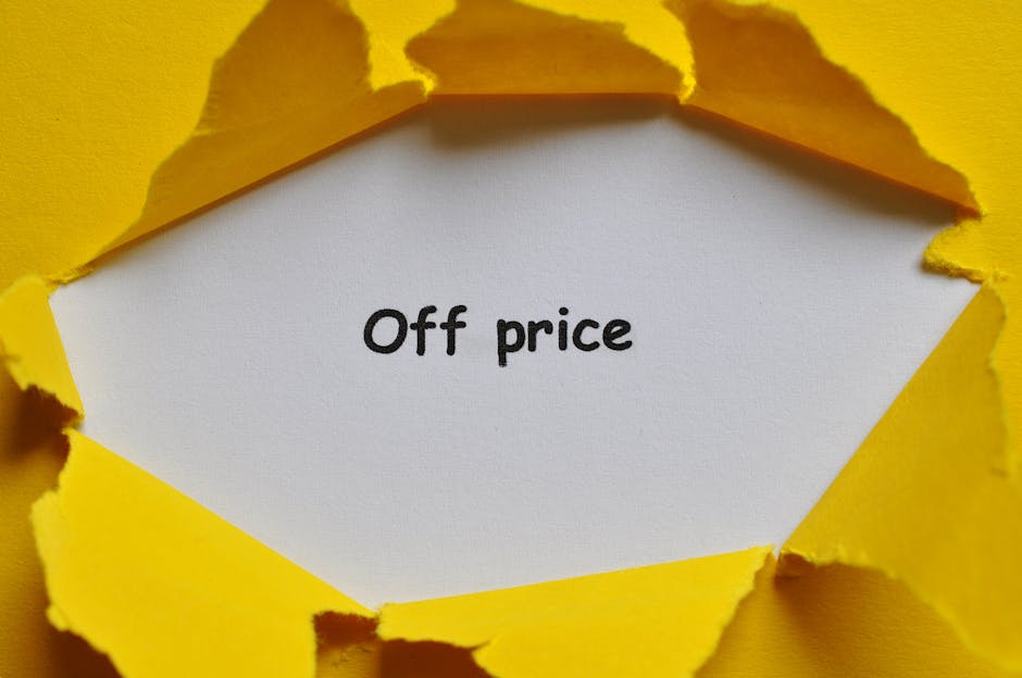 A close-up image showing a torn yellow paper wrapping with jagged edges revealing a white sheet inside that has the phrase 'Off price' written in black text. The torn paper appears to be part of packaging material used during a home relocation or furniture transport process. The environment is well-lit, emphasizing the contrast between the bright yellow paper and the white background, which highlights the packing and moving activities typical of professional removals by Man with Van St Margarets. The focus is on the packing material, illustrating the careful handling and preparation of items for transport within a house removal service.